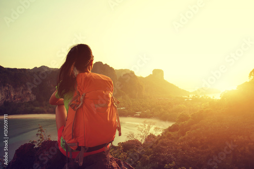 young woman backpacker hiking on seaside mountain