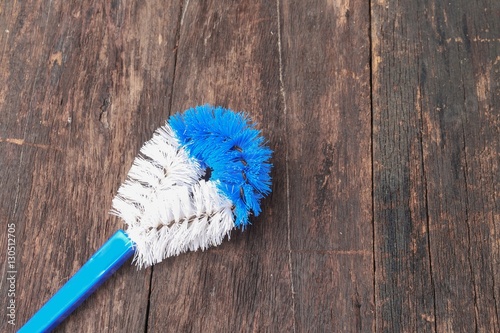 brush cleaning toilet on wooden floor background with copy space