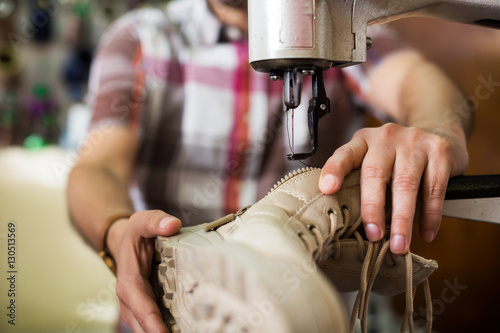Foto Shoemaker stitching footwear on machine