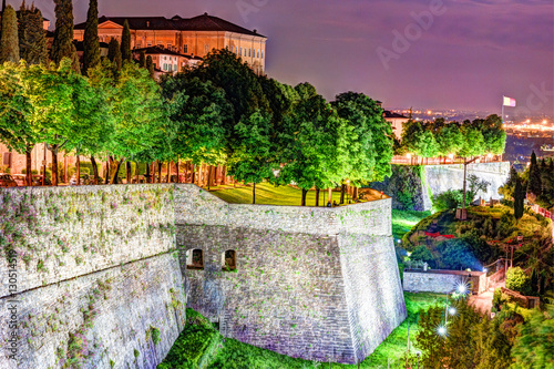 Stone walls of Castle La Rocca in Bergamo old town, Italy under the night lights.