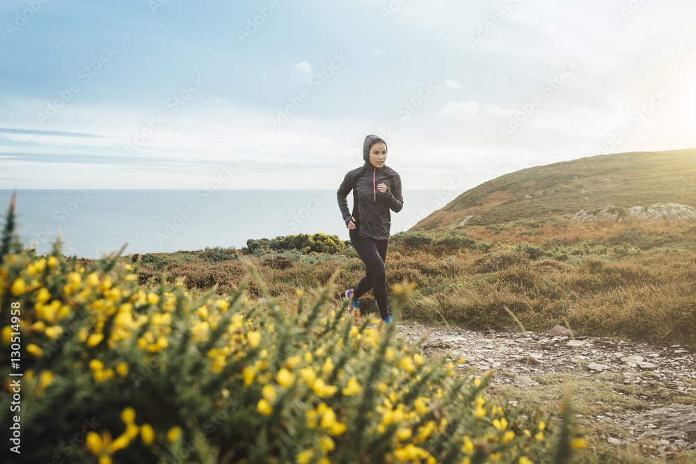Ireland, Howth, woman running on coastal path Ireland, Howth, woman running on coastal path