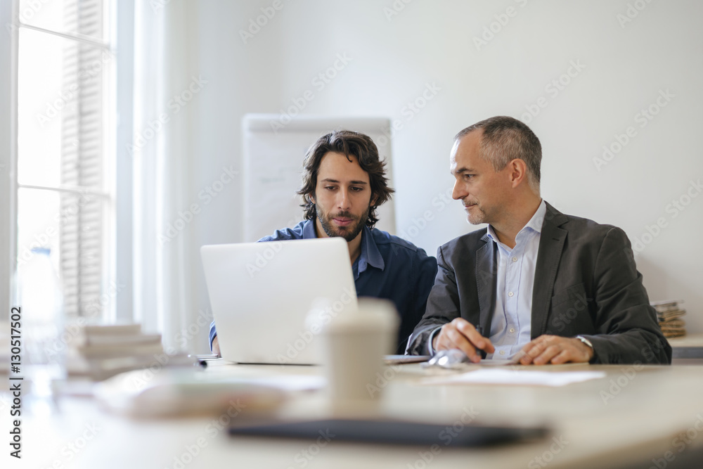 Two businessman working together in office Two businessman working together in office