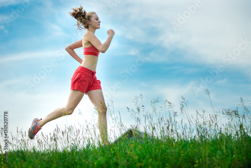 Young lady running. Woman runner running through the summer park rural road. Workout in a park. Beautiful fit girl. Fitness model caucasian ethnicity outdoors. Weight loss exercise. Jogging. © mr.markin