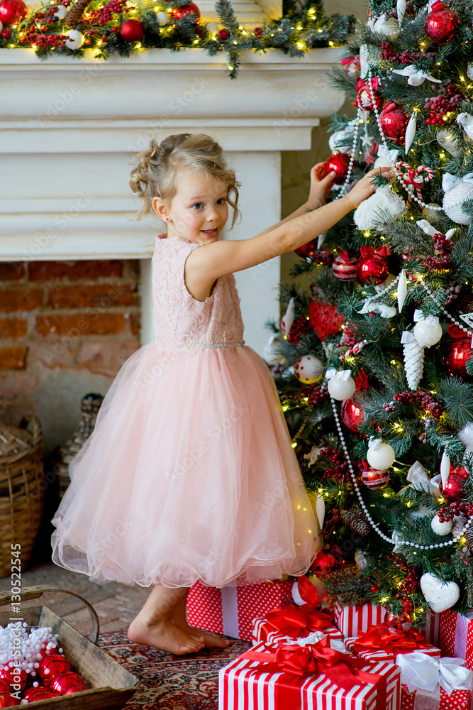 little girl decorating Christmas tree at home little girl decorating Christmas tree at home
