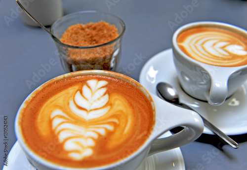 Cups of cappuccino and brown sugar photo