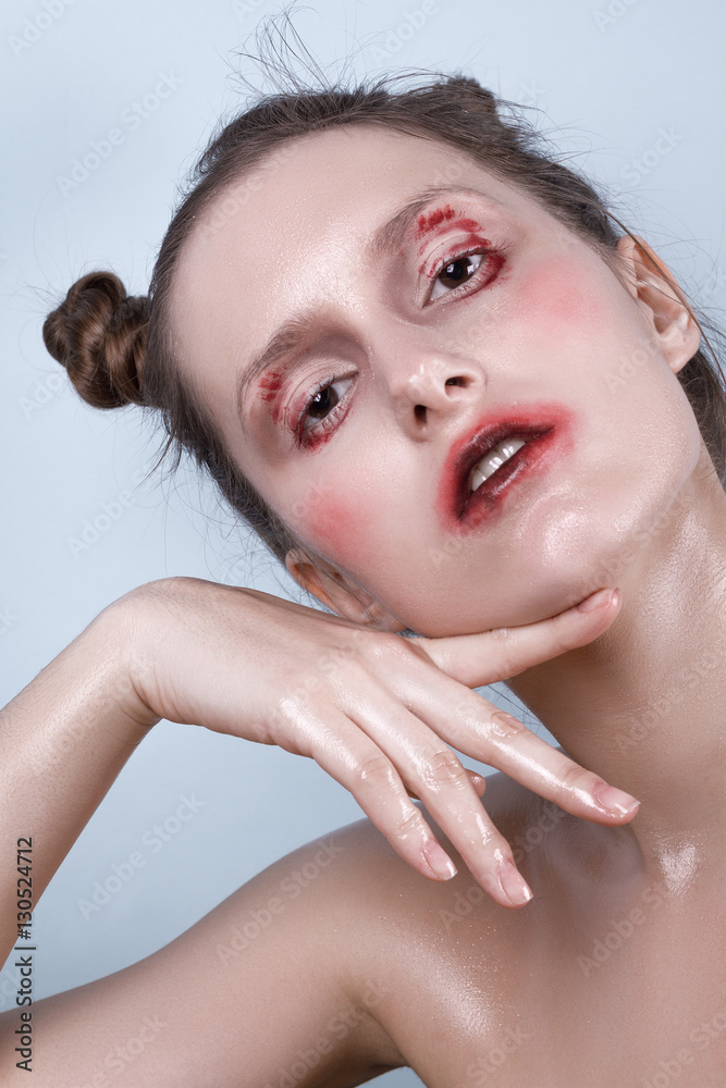 Naklejka premium Girl with wet make-up posing emotionally on a blue background