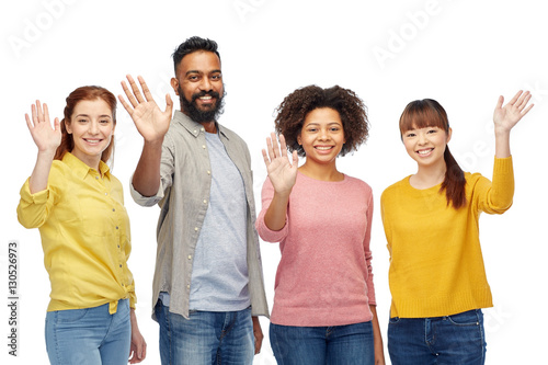 international group of happy people waving hands