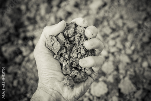 Valokuva dry soil in human hand - aridity concept - black and white photo