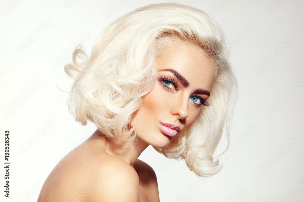 Vintage style portrait of young beautiful tanned sensual platinum blonde girl with stylish make-up and hairdo