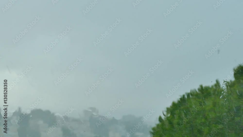 Rain drops hitting a window on a stormy day