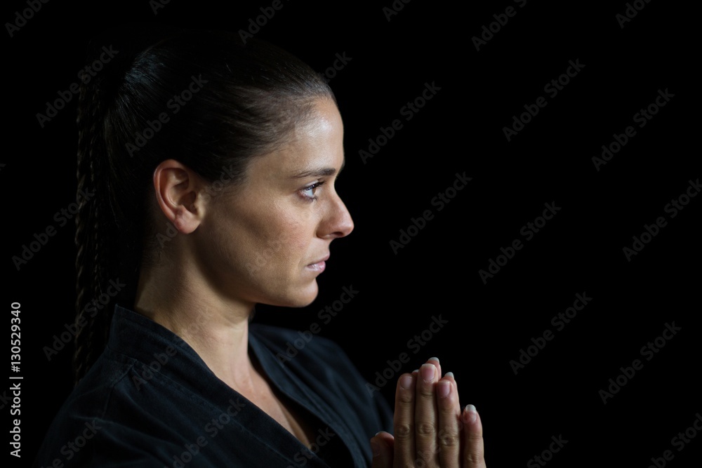 Female karate player in prayer pose Female karate player in prayer pose