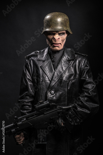 Angry baboonish man in black clothes on dark background