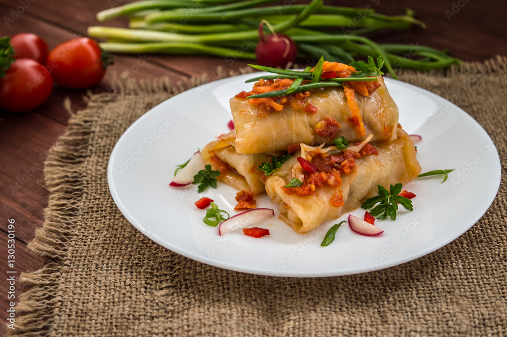 Cabbage rolls in tomato sauce. white plate. wood background. Cabbage rolls in tomato sauce. white plate. wood background.