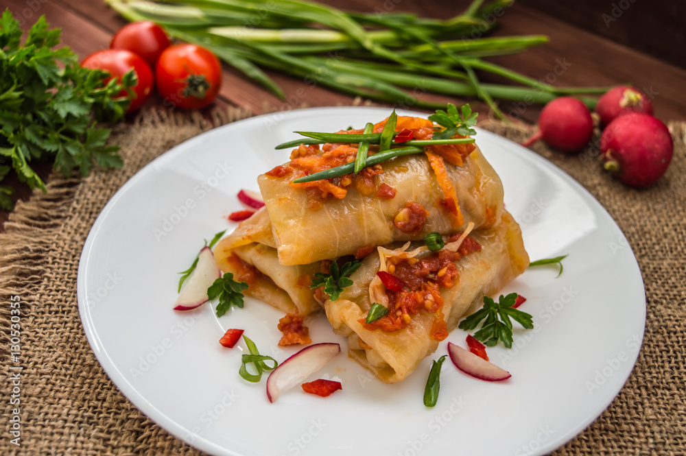 Cabbage rolls in tomato sauce. white plate. wood background. Cabbage rolls in tomato sauce. white plate. wood background.