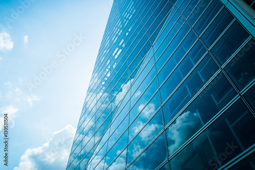 View of modern contemporary glass skyscraper reflecting the blue sky