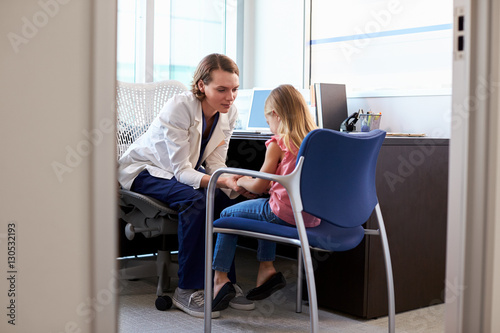 Pediatrician Talking To Unhappy Child In Hospital