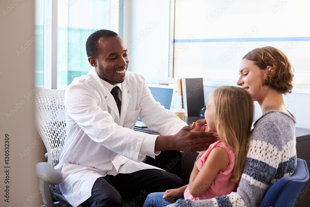 Pediatrician Examining Child In Hospital Pediatrician Examining Child In Hospital