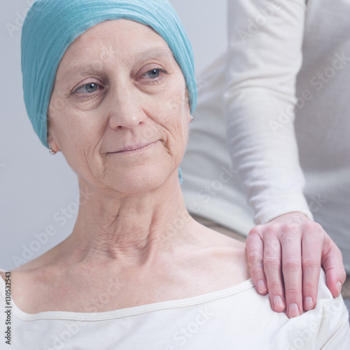 Person holding cancer woman's arm