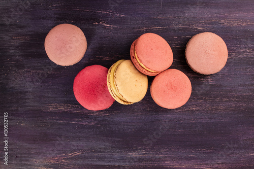 Various macarons on vibrant purple texture with copyspace