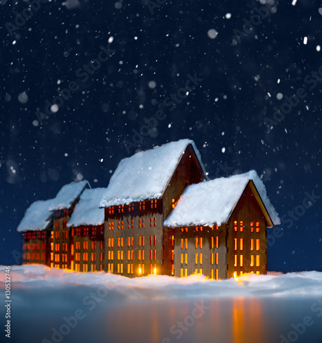 Christmas scene. Decorative houses, covered with snow, with christmas lights.