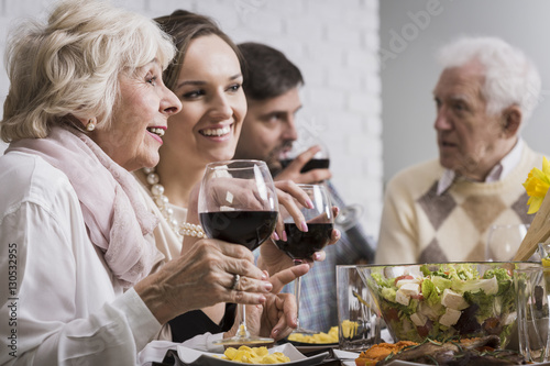 Women drinking wine during family dinner