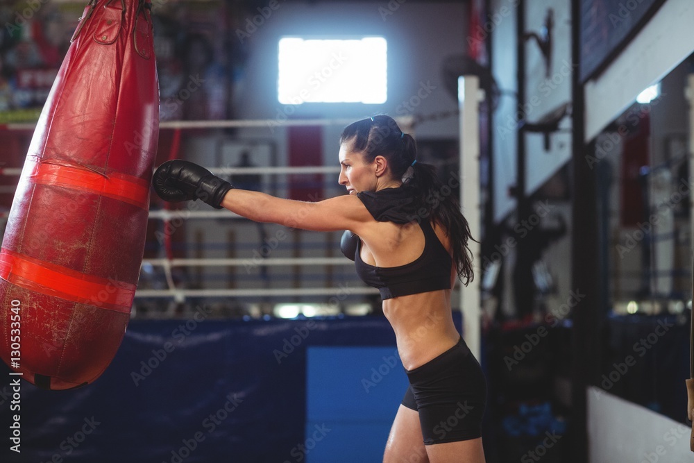 Female boxer practicing boxing with punching