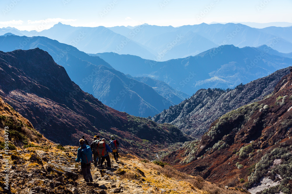 Group of People with Backpacks walking on Trail on Himalaya Trek