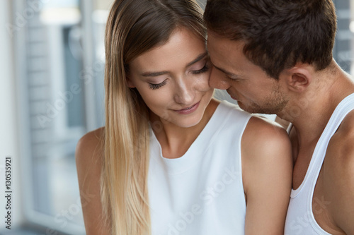 Portrait Of Handsome Man Kissing Happy Woman With Soft Face Skin
