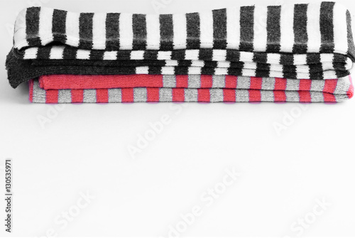 pile of multicolored knitted striped scarf isolated on white background haze filter