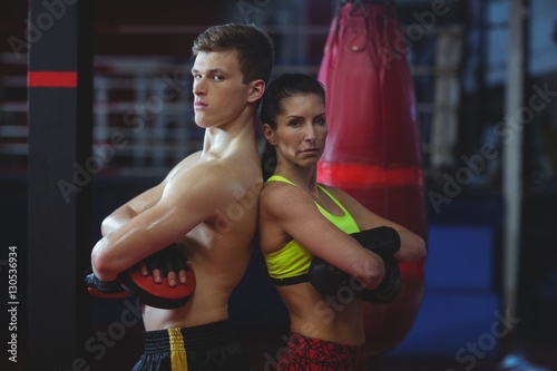 Female and male boxer standing back to back