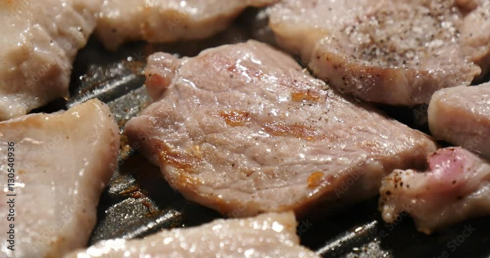 Turning pork belly in frying pan Turning pork belly in frying pan