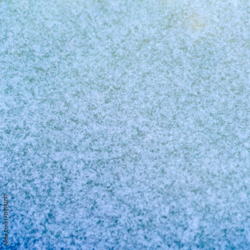 Background with green ice, covered with snowflakes