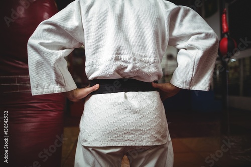 Mid section of karate player with hands on hips