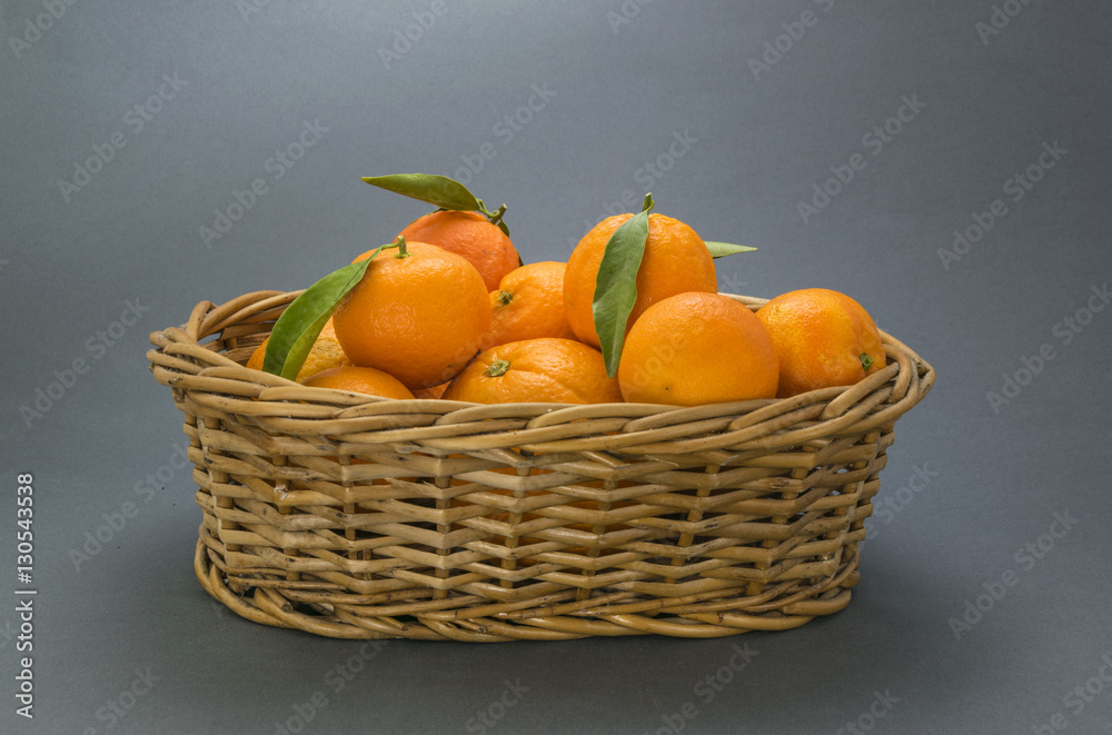 Oranges and mandarins with basket on blue background Oranges and mandarins with basket on blue background