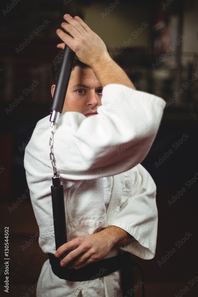 Karate player practicing with nunchaku