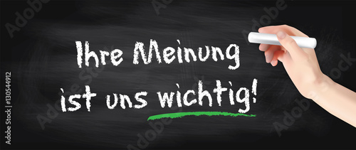 Hand schreibt auf Kreidetafel - Ihre Meinung ist uns wichtig