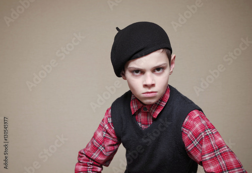 Boy in a beret with a grumpy face. photo