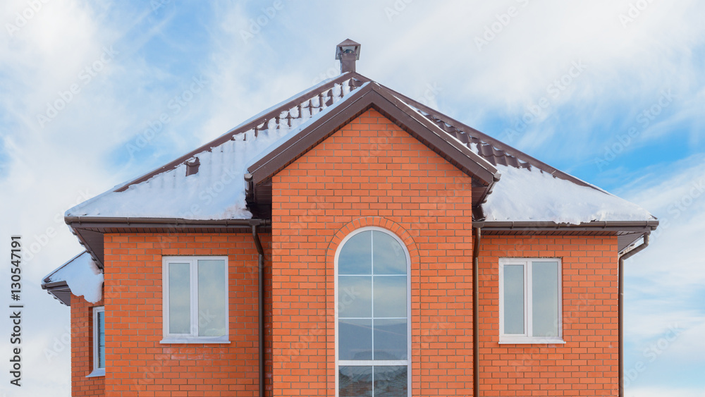 brick apartment house with a snow-covered roof
