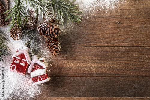 snowy cones and red houses powdered with snow on a wood background