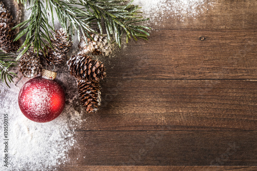 snowy cones and a red globe powdered with snow on a wood background