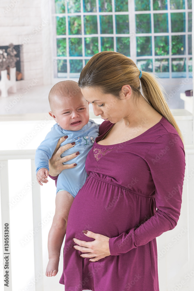 Young pregnant woman holding baby her arms Young pregnant woman holding baby her arms