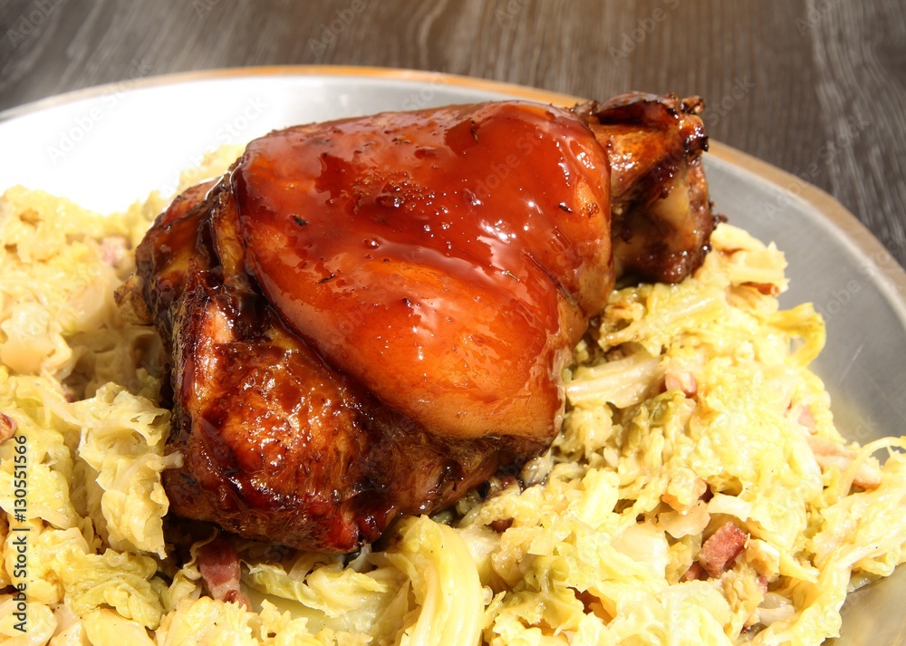 jarret de porc laqué au miel et soja sur un lit de chou vert braisé aux