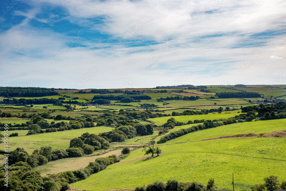 Stunning green British countryside under cloudy blue skies