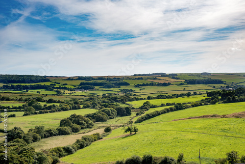 Stunning green British countryside under cloudy blue skies