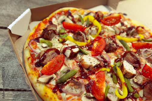 Fresh tasty pizza on wooden background