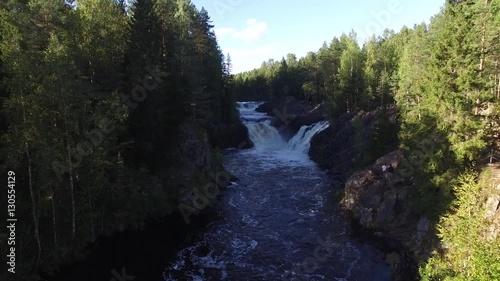 Flying over beautiful waterfall in the forest. Waterfall Kivach in Karelia. Aerial view. photo