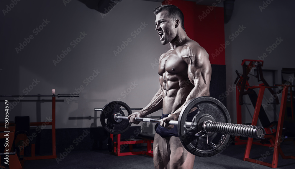 Muscular bodybuilder guy doing exercises with dumbbell Muscular bodybuilder guy doing exercises with dumbbell