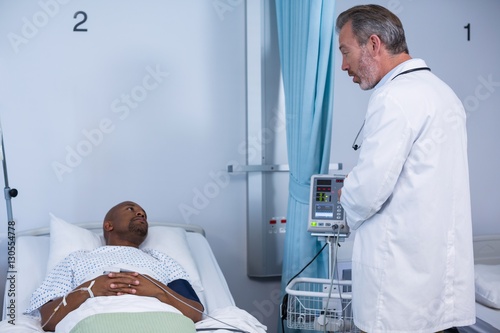 Doctor interacting with patient during visit in ward
