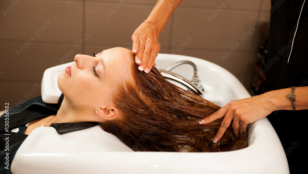 Obraz premium Hair stylist at work - hairdresser washing hair to the customer