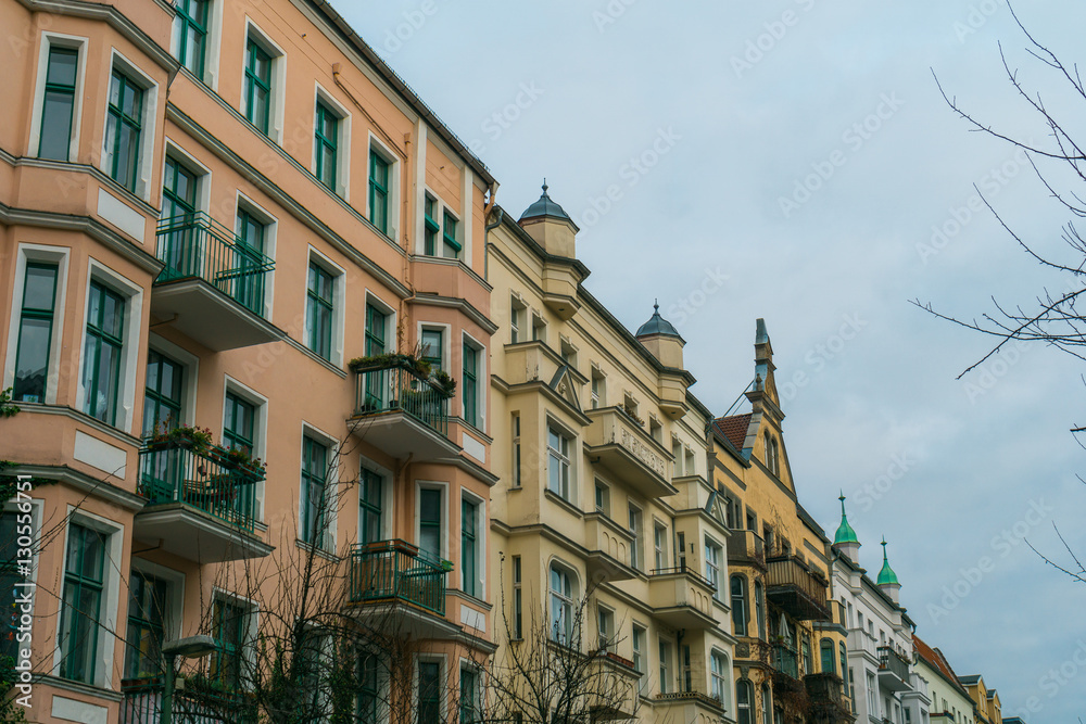 pink and yellow facaded apartment houses in a row at berlin, germany